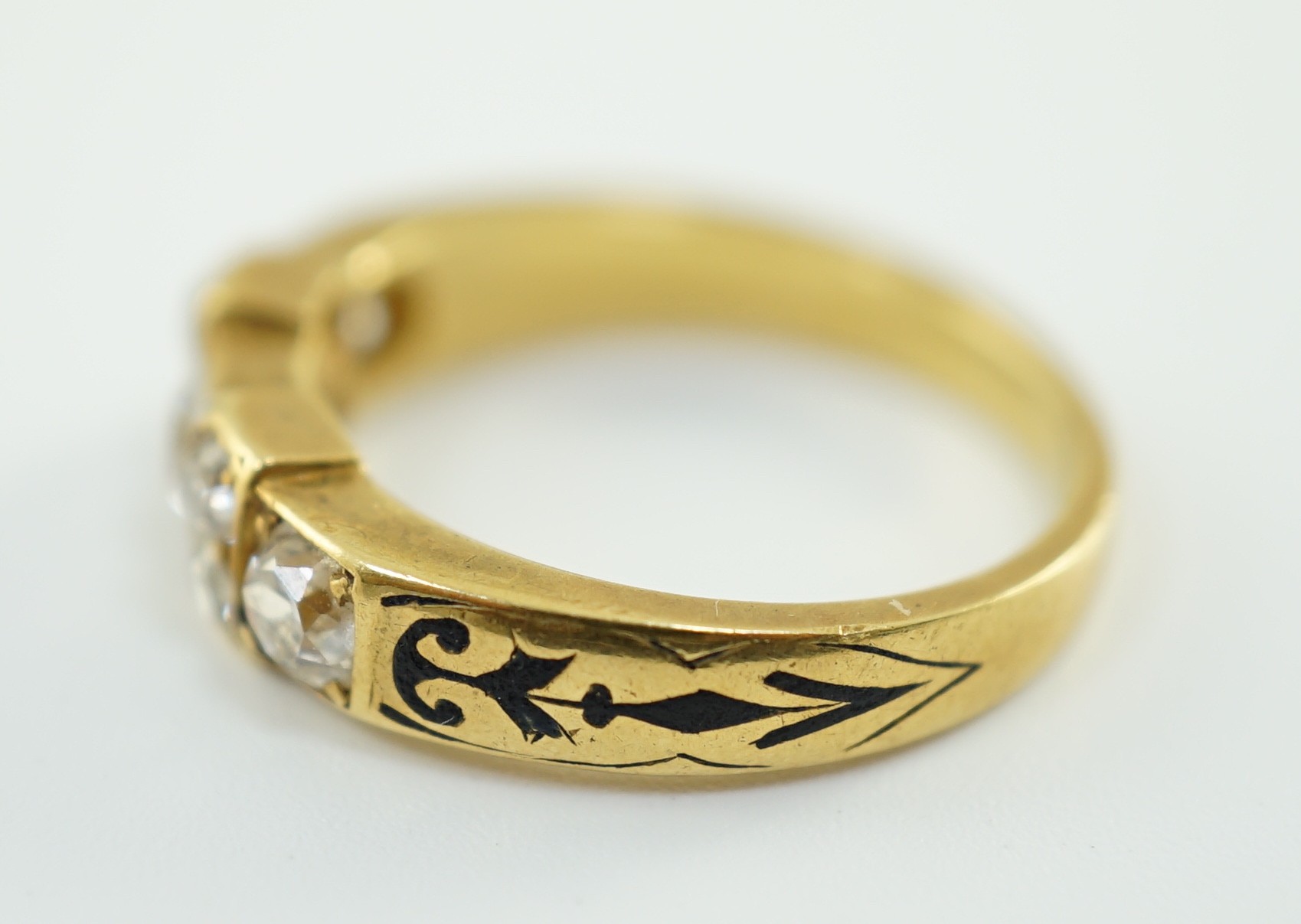A late 19th century gold and seven stone old mine cut diamond and black enamelled cluster half hoop ring